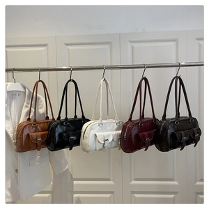 Five retro underarm Boston bags in brown, black, and beige colors on a display