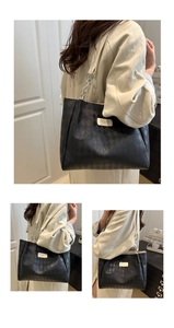 Close-up of black quilted tote bag showing rhombus texture and silver chain strap