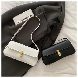 Detail of elegant litchi grain leather handbags with golden U-shaped metal buckles