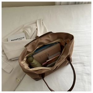 Dettaglio interno di una grande borsa tote color terra con spazio per libri e un ombrello