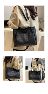 Detailed view of black tote bag with diamond quilted texture and silver chain strap