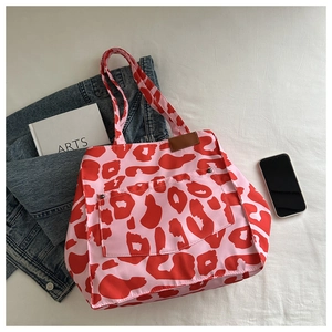 Pink and red leopard print tote bag styled with denim jacket and daily essentials