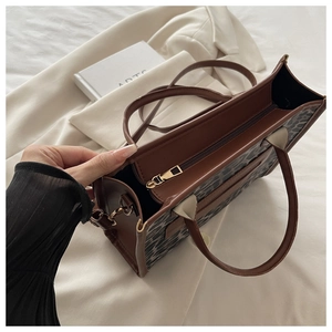 Vista dall'alto di una borsa tote leopardata con zip dorate e tracolla rimovibile