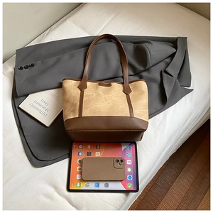 Detailed view of spacious beige and brown tote bag with tablet showing large capacity