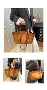 Detail of brown suede tote bag featuring dual handles and spacious interior design