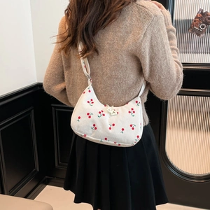 White corduroy underarm bag with cherry pattern and wide strap shown on model