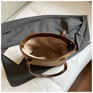 Top view of large tote bag interior showing beige lining and zip closure on grey suit