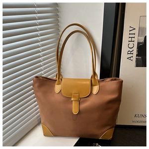 Dettaglio della borsa tote in nylon marrone con finiture in pelle gialla e angoli rinforzati