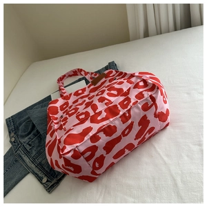 Fashionable large capacity pink leopard print tote bag placed on white bedding with denim jacket