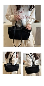 Detail view of large black tote bag with dual-material splicing and white contrast stitching