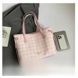 Dettaglio borsa shopper a quadretti rosa e bianchi con manici lunghi e accessori