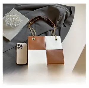 Détail du sac à bandoulière carré en cuir bicolore avec bandoulière chaîne dorée