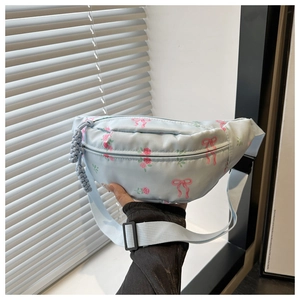 Detail van de lichtblauwe nylon schoudertas met roze strikken en rode rozenprints