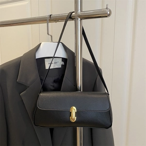 Minimalist black grained leather underarm bag with gold cylindrical metal lock detail
