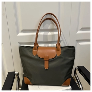 Dettaglio della borsa tote in nylon verde con angoli in pelle e chiusura a fibbia