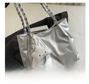 Detail of silver pleated tote bag with braided handle and white plush cloud charm