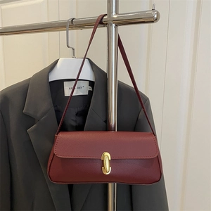 Minimalist burgundy litchi leather baguette bag with a gold oval twist lock for women
