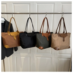 Dettaglio di quattro borse tote in nylon colorate con manici e angoli rinforzati in pelle