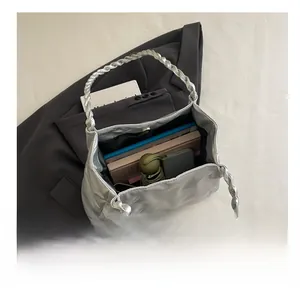 Top view showing the large internal capacity of a silver quilted tote bag with daily items