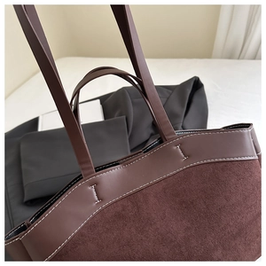 Detailed close-up of dark brown two-tone tote bag with contrasting white stitching