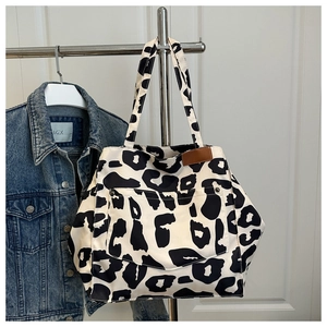 Detail of leopard print nylon tote bag featuring decorative pocket and brown leather patch