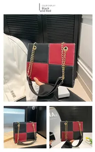 Détail du sac carré bicolore rouge et noir avec chaîne dorée et coutures blanches