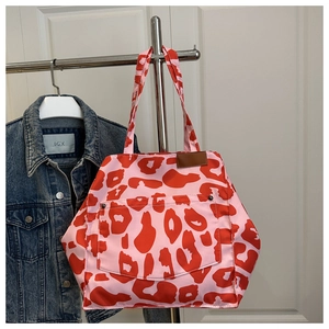 Close-up of pink leopard print tote bag with front rivet pocket and leather accents