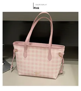 Dettaglio della borsa tote a quadri rosa con logo dorato e lacci decorativi laterali