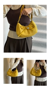 Macro detail of yellow hobo bag with a suede finish and silver heart charm on bow