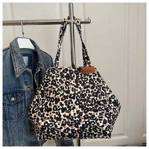 Detailed view of leopard print tote bag with functional front pocket and brown trim