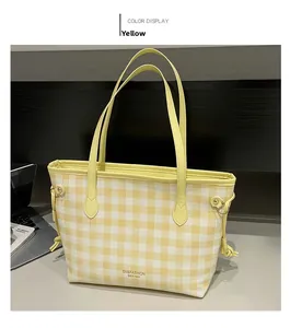 Dettaglio della borsa tote a quadri gialli con coulisse laterali e manici sottili chic