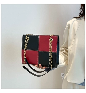 Détails d'un sac à damier avec coutures blanches et bandoulière en chaîne dorée