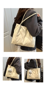 Detail of off-white tote bag featuring geometric quilting and braided handle textures