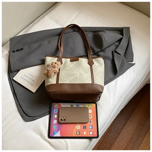 Detail view of large canvas tote bag showing interior capacity and bear charm