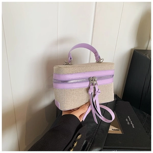 Detail of color-block tote bag featuring purple leather and beige woven fabric texture