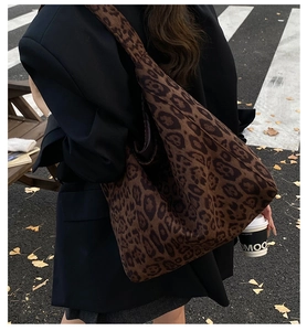 Close-up of a large leopard print tote bag on a street with autumn leaves background