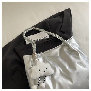 Detail of silver metallic tote with twill texture and cute white cloud charm