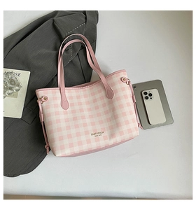 Detailed view of pink plaid tote bag with side drawstrings and brand lettering