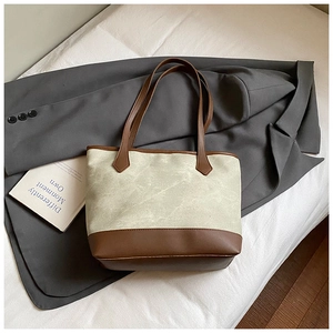 Detail of vintage canvas tote bag with contrast brown leather trim and shoulder straps