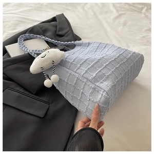 Détail du sac cabas bleu clair avec tissu texturé bulle et pendentif nuage en peluche