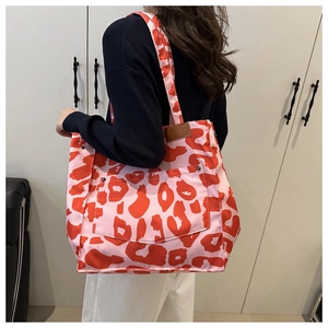 Detailed view of fashionable large tote bag with pink and red leopard print and strap