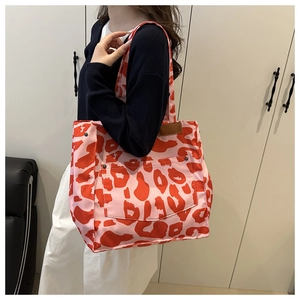 Detail of pink leopard print tote bag with metal rivets and large front pocket for storage