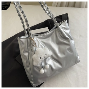 Detail of silver metallic tote bag with twisted rope straps and plush cloud charm