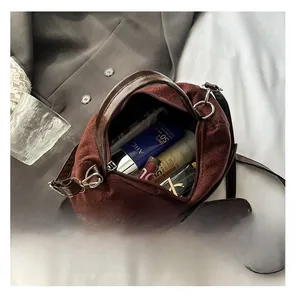 Detail view of the spacious interior of the brown suede bucket bag with daily items