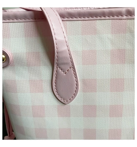 Detail of pink plaid tote bag showing stitching on shoulder strap and gold hardware