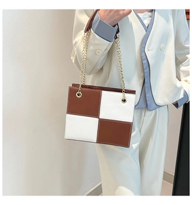 Détail du sac à bandoulière à damier avec texture cuir brillant et chaîne dorée