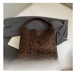Detail of vintage leopard print tote bag with wide integrated handle on a grey blazer