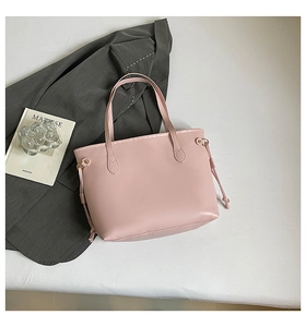 Detailed view of pink leather tote bag with drawstring accents on a grey blazer background