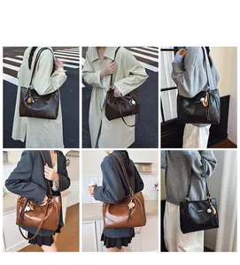 Detail of dark coffee PU leather tote bag with elegant metallic logo and side tassel