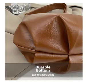 Detail view of the pleated base texture on the brown leather tote with wear-resistant design